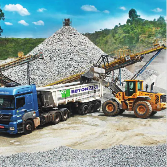 Trator enchendo caminhão Beton Mix de brita